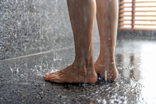 2 Füße auf Fließen im Bad