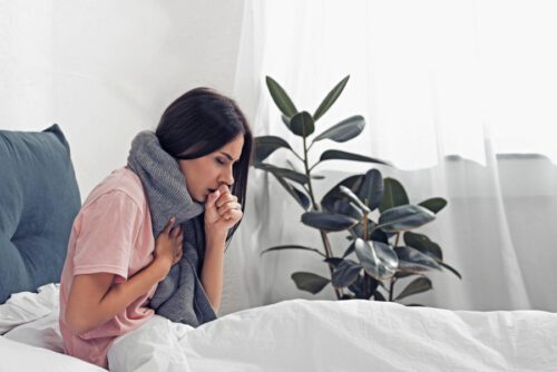 Hustende Frau im Bett