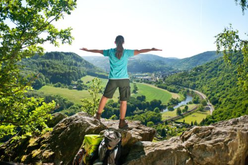 Wanderin steht auf Felsvorsprung an der Lahn