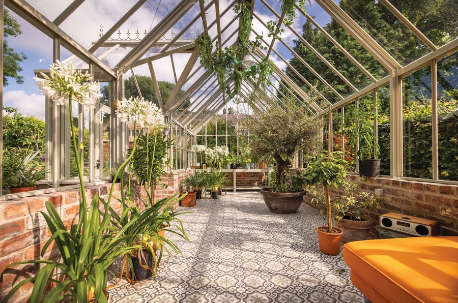 Glashaus von innen mit Blumen und Pflanzen