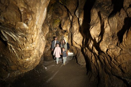 Familie mit zwei Kindern laufen durch eine Höhle