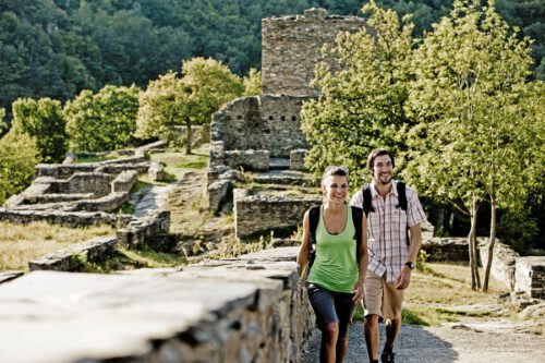 Päärchen wandert vor Burgruine