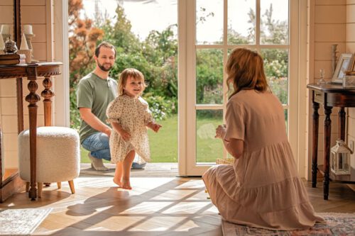 Kleine Familie steht an der Terrassentür